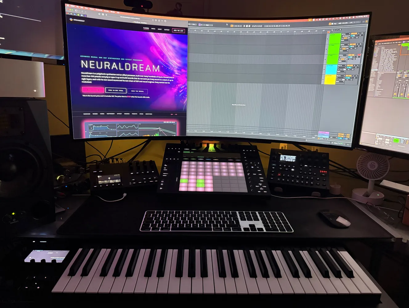 The main desk with NeuralDream on the wide screen and a pad controller and a keyboard in front of it.